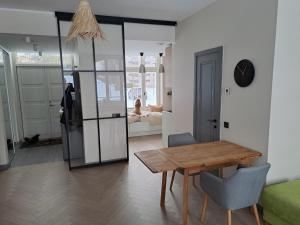 Sissi Apartment Aleksandri 32 في تارتو: غرفة معيشة مع طاولة خشبية وغرفة طعام