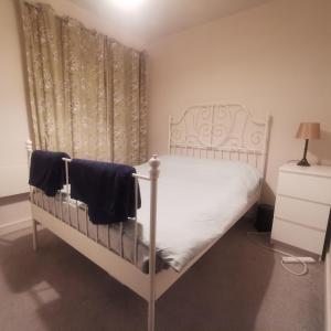 uma cama branca num quarto com uma cortina em 1 Bed Apartment in Cardiff Bay -Dixie Buildings em Cardiff