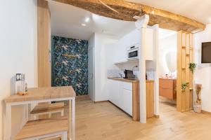 a small kitchen with a wooden table and a stove at L'Eden Zen - Suite Jacuzzi, parking, clim, Netflix in Béziers +17 photos