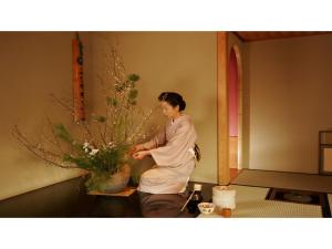 a woman standing next to a vase of flowers at Toi Fujiya Hotel - Vacation STAY 27089v in Izu +13 photos