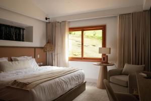 a bedroom with a bed and a window and a chair at Mountains Of Hope in Rionegro