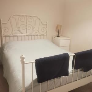 um quarto com uma cama branca e toalhas pretas em 1 Bed Apartment in Cardiff Bay -Dixie Buildings em Cardiff