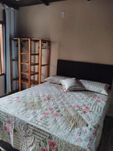 a bed with a quilt on it in a bedroom at Flat Raio de Sol - Taipu de Fora in Marau
