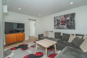 uma sala de estar com um sofá e uma televisão em Central Edmonton Family Friendly Home em Edmonton