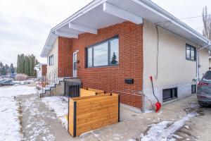 une maison en briques avec une clôture en bois devant elle dans l'établissement Central Edmonton Family Friendly Home, à Edmonton