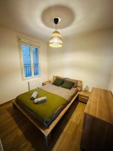 a bedroom with a bed with a green blanket at Appartement F3 - Palais de Justice in Le Havre