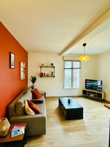 a living room with a couch and a tv at Appartement F3 - Palais de Justice in Le Havre