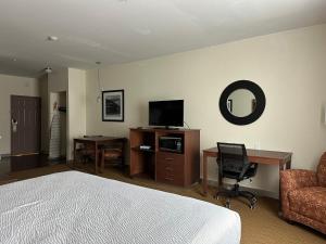 a bedroom with a bed and a desk and a chair at Expo Inn and Suites Belton Temple South I-35 in Belton