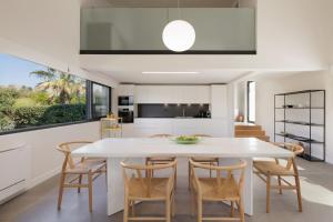 a kitchen and dining room with a white table and chairs at Gaia - A Secret Luxury Hideaway in Achílleion