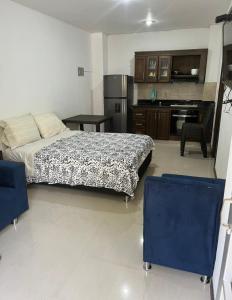 a large bedroom with a bed and a kitchen at Apartaestudio cerca a Plaza Mayor in Medellín