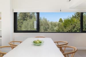 a white table with a bowl of fruit on it at Gaia - A Secret Luxury Hideaway in Achílleion +30 photos