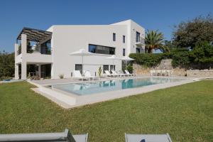 a villa with a swimming pool in front of a house at Myrtia - Luxury Hidden Gem in Corfu Town