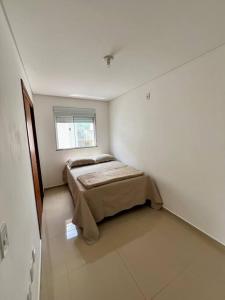 1 dormitorio con 1 cama en una habitación blanca en Casa prox. a praia do Campeche en Florianópolis