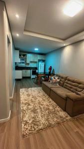 uma sala de estar com um sofá castanho e um tapete em CASA DE PRAIA -Palmas Governador Celso Ramos, Sc em Governador Celso Ramos