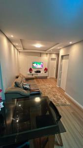 un soggiorno con un divano e una TV di CASA DE PRAIA -Palmas Governador Celso Ramos, Sc a Governador Celso Ramos