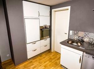 a kitchen with white cabinets and a sink at Ferienwohnung im Mittelrheintal, Traumschleife & Rheinsteig Wanderwege! in Damscheid +2 photos