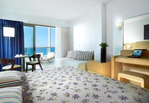 a hotel room with a bed and a living room at Albatros Spa & Resort Hotel in Hersonissos