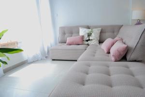 salon z kanapą i różowymi poduszkami w obiekcie Apartamento con vistas al mar w Alicante