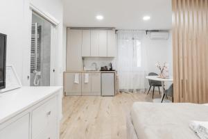 a white room with a kitchen and a table at Classy & Cozy apartment in Ljubljana