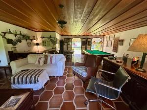 a living room with a couch and a pool table at Sítio Mato Dentro in Atibaia +40 photos