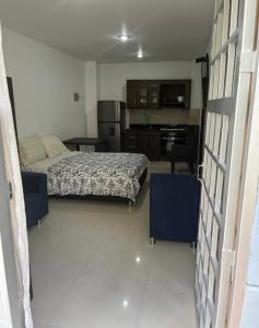 a small bedroom with a bed and a kitchen at Apartaestudio cerca a Plaza Mayor in Medellín