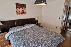 a bedroom with a bed with a blue comforter at 2 Bedroom Apartment Central Birmingham City Centre ( Parking ) in Birmingham