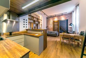 an open kitchen and dining room with a brick wall at Warsaw Concierge Metro Loft in Warsaw