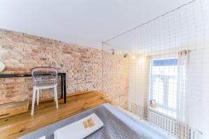 a room with a brick wall and a chair at Warsaw Concierge Metro Loft in Warsaw