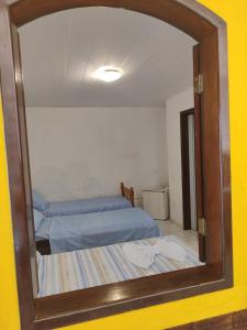 a mirror reflection of a bedroom with a bed in it at Pousada Encantos de Maceió in Maceió