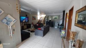 a living room with a couch and a tv at Pousada Leher in São Gabriel