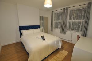 a bedroom with a bed with a shoe on it at Harlesden House in London