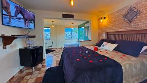um quarto com uma cama com flores vermelhas em Chalés Mirante das Pedras em Monte Verde