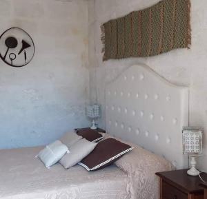 - une chambre avec un lit blanc et une tête de lit blanche dans l'établissement Giardini di Marzo, à Felline