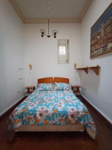1 dormitorio con 1 cama con un edredón colorido en Hostal Tulio Porteño, en Valparaíso