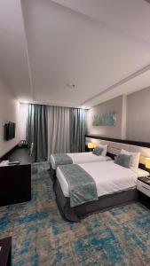 Habitación grande con 2 camas y TV. en فندق اوبن هوتيل مكه المكرمه en La Meca