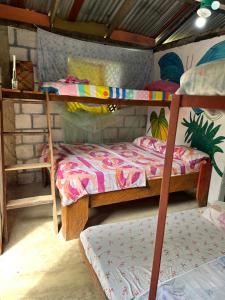 a bedroom with two bunk beds in a room at Posada El Silbo Apacible Cabaña, Glamping y Camping in Playa Ladrilleros