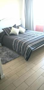 1 cama con almohadas en el dormitorio en Mirador Uno en Concepción