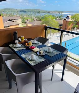 a table with a tray of food on a balcony at Apartamento EcoResort Carneiros in Praia dos Carneiros