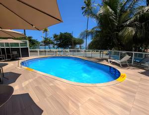 a swimming pool on a deck with a table and chairs at Flat Radisson Recife in Recife