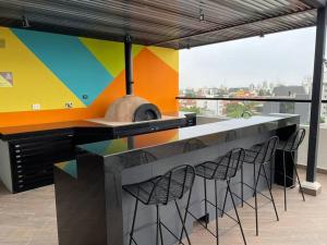 eine Küche mit einer farbenfrohen Wand mit einem Herd und Stühlen in der Unterkunft Lujo y comodidad en Zona Norte in Santa Cruz de la Sierra + 9 Fotos