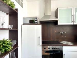 a kitchen with a white refrigerator and a sink at Großzügiges Stadtapartment an der Flaniermeile in Kassel