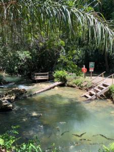 un ponte su un fiume con pesci in acqua di Hotel Santa Esmeralda a Bonito