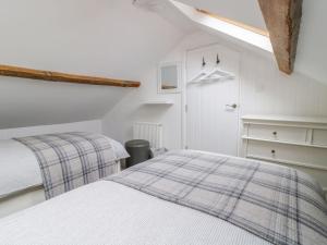 a white bedroom with two beds and a closet at 23 Chapel Street in Conwy