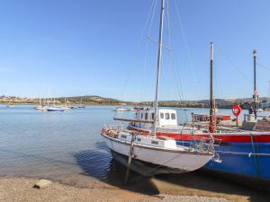 two boats docked on the shore of a harbor at 23 Chapel Street in Conwy