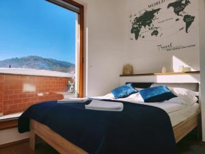 1 dormitorio con 1 cama grande y ventana en MOARI pokoje gościnne, en Szczyrk