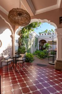 eine Terrasse mit einem Tisch und Stühlen in einem Gebäude in der Unterkunft Ojala in Antigua Guatemala