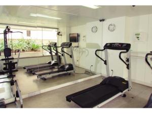 un gimnasio con 3 cintas de correr y un espejo en Condomínio Max Savassi Superior apto 1302 en Belo Horizonte