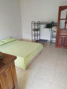 Schlafzimmer mit einem Bett, einem Tisch und einer Tür in der Unterkunft Tu Hogar en la Tierra del Cacao 