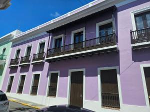 a purple building with balconies on a street at KASA San Francisco 1 in San Juan