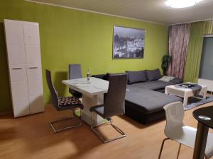 a living room with a couch and a table and chairs at Komfortable Ferienwohnung in Flörsheim-Weilbach in Flörsheim